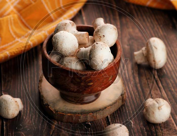 Fresh Whole Organic Mushrooms In A Wooden Bowl