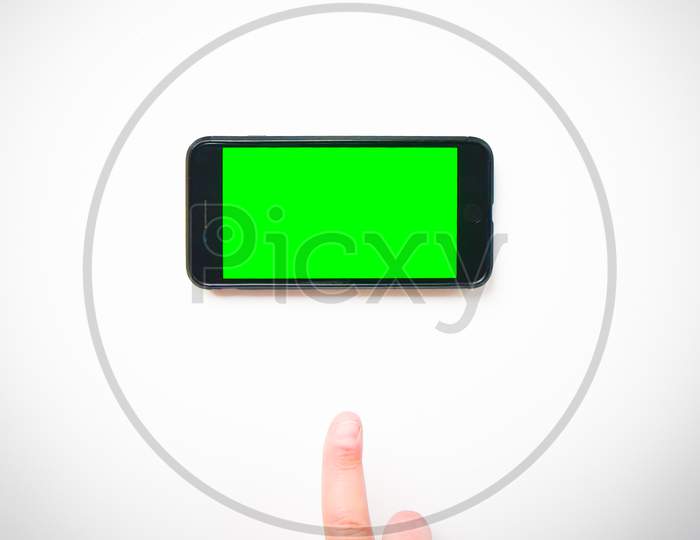 Male Hand Finger Up To Smartphone Green Screen On A White Background Curtains. Isolated Blank Space Copypaste Smartphone Background Mock Up