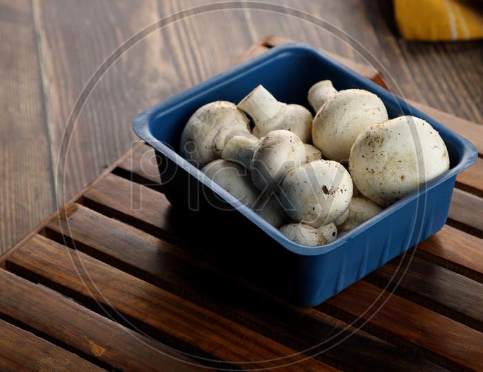Fresh Uncooked Organic Button Mushrooms In Retail Plastic Box