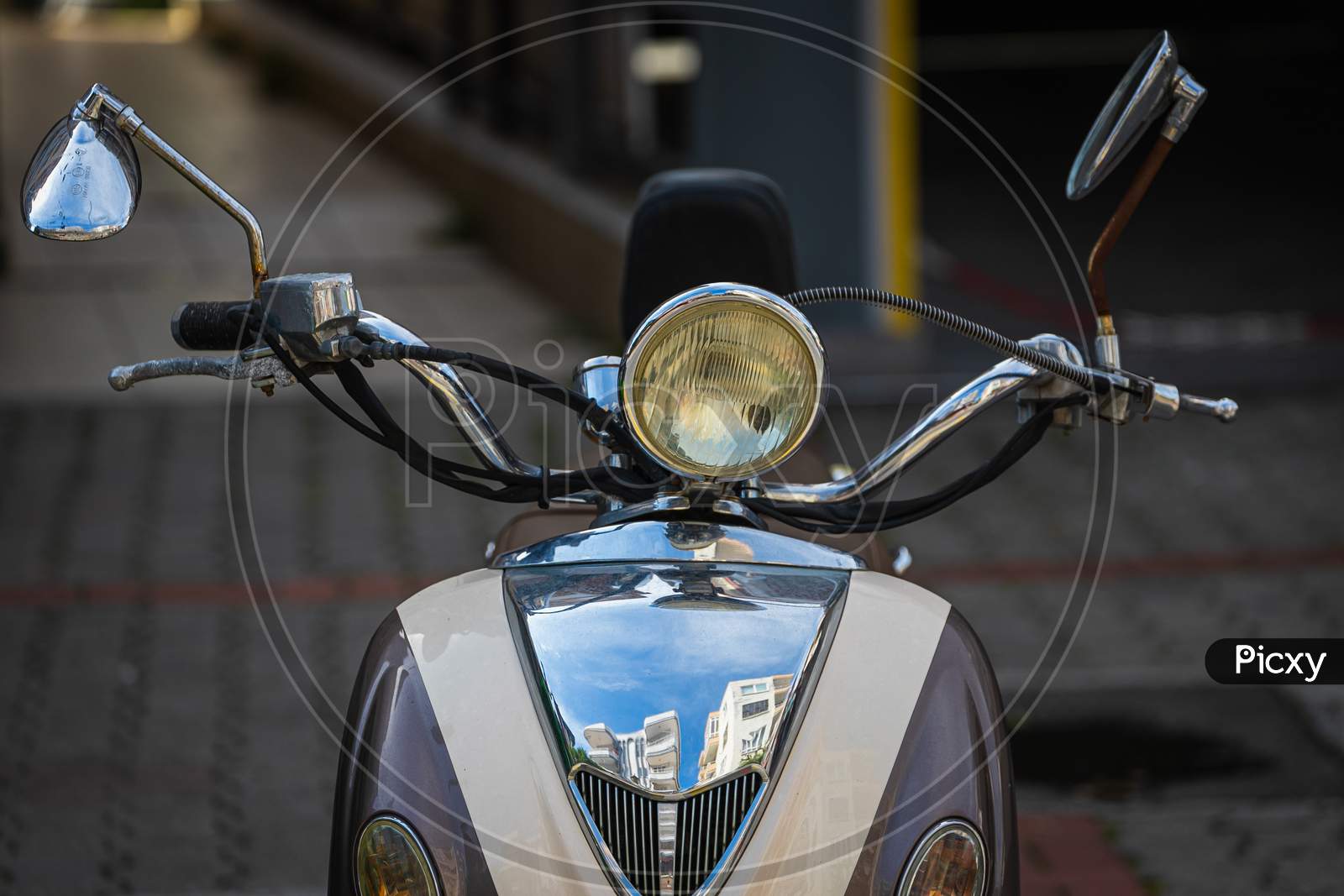 A Vintage  White   Motorcycle, Moped  Stands In A Parking Against The Backdrop Of  Gray Wall. Front  View