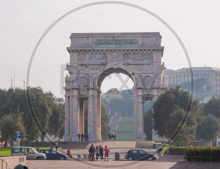 Genoa, Italy - March 16, 2014: Tourists Visiting Arco Della Vittoria Marble Arch Which Was Designed By Marcello Piacentini In 1924 As Part Of Piazza Della Vittoria Redesign