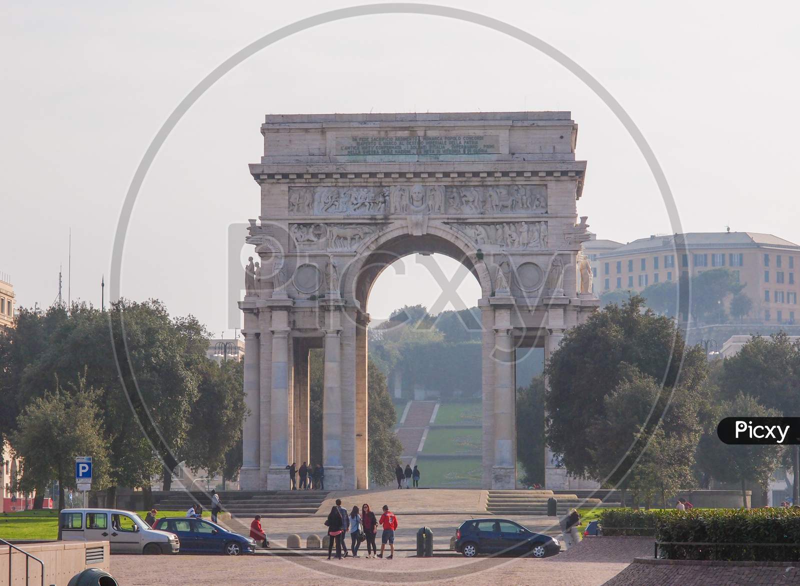 Genoa, Italy - March 16, 2014: Tourists Visiting Arco Della Vittoria Marble Arch Which Was Designed By Marcello Piacentini In 1924 As Part Of Piazza Della Vittoria Redesign