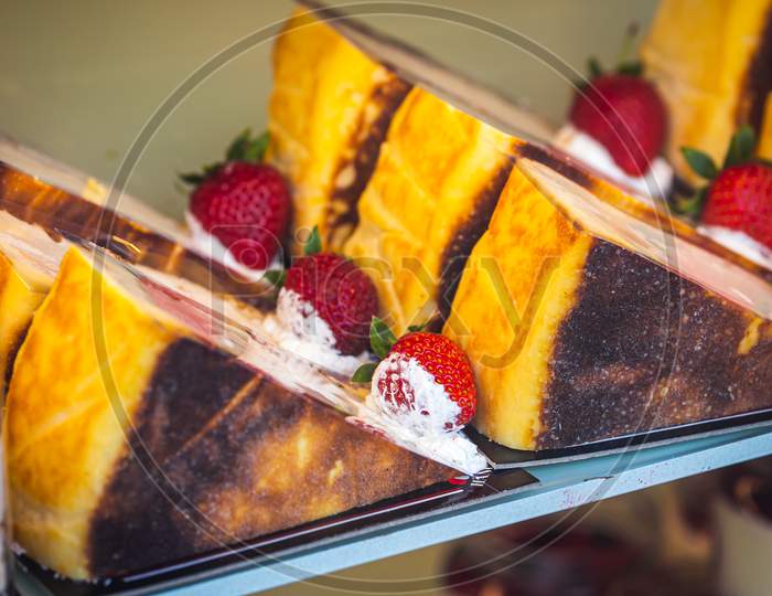 Close-Up Of Identical Pieces Of Cake With Cream Filling, Strawberries
