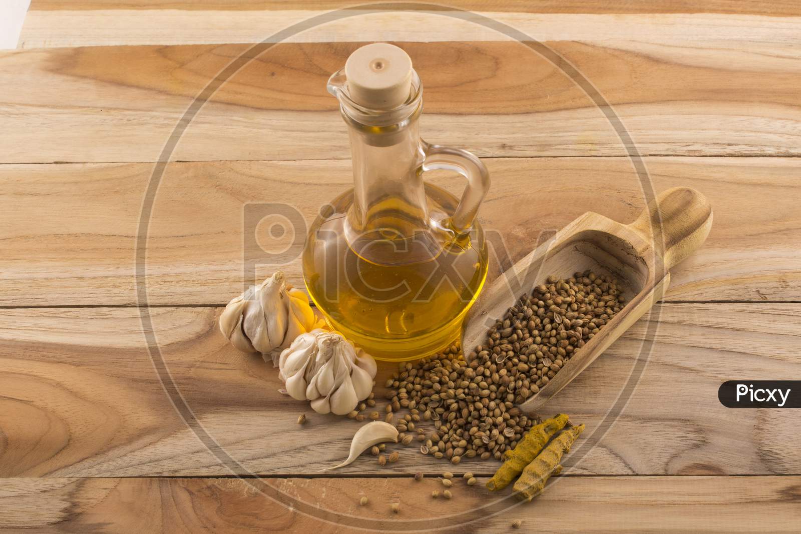 Garlic, Turmeric And Wooden Spoon With  Essential Oil In A Bottle And Wooden Background Stock Photo