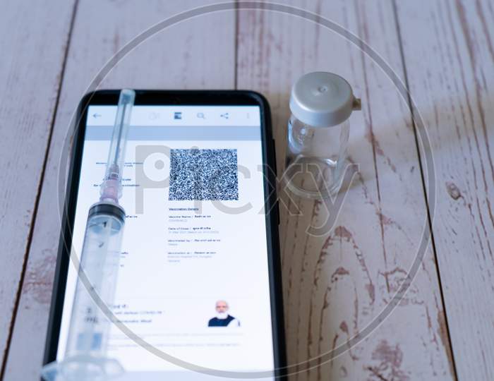 Mobile Phone With Digital Covid 19 Coronavirus Vaccination Certificate Given After Two Doses Of Covishield Covaxin In The Co-Win Cowin App Shown With Syringe And An Empty Vial