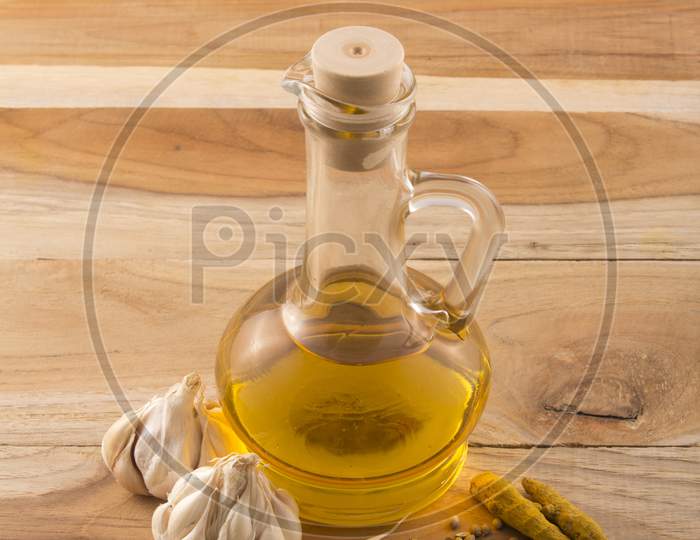 Garlic, Turmeric With  Essential Oil In A Bottle And Wooden Background Stock Photo