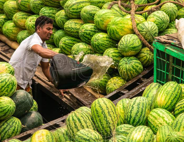 Man Cleaning Water From The Watermelon Boat. I Captured This Image From Sadorghat, Bangladesh, Asia