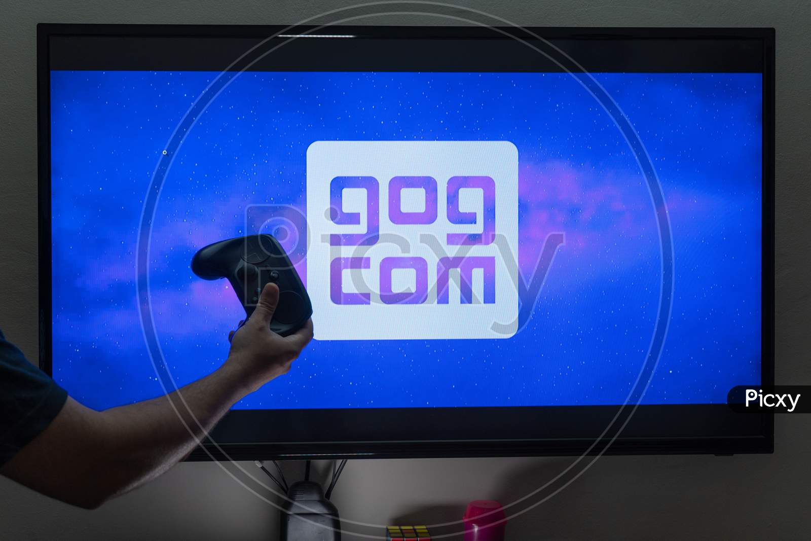 Man Holding A Controller In Front Of The Loading Screen For The Gog Good Old Game Store With Drm Free Titles Like Cyberpunk Witcher And More
