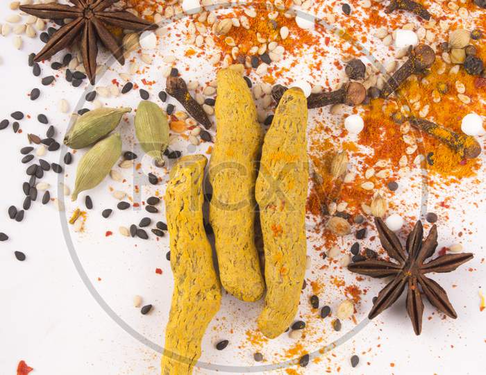 Spices: Turmeric, Chilly Powder, Cardamom And Anise Stars  On Ground With White Background Stock Photo