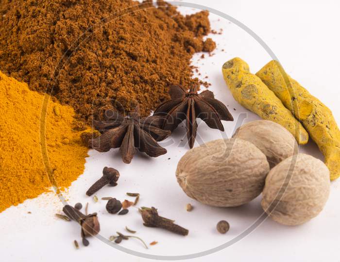 Spices: Turmeric, Chilly Powder, Nutmegs And, Anise Stars On Ground With White Background Stock Photo