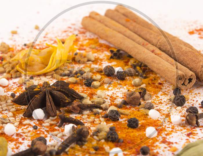 Spices: Turmeric, Chilly Powder, Cardamom And Cinnamon, Anise Stars On Ground With White Background Stock Photo