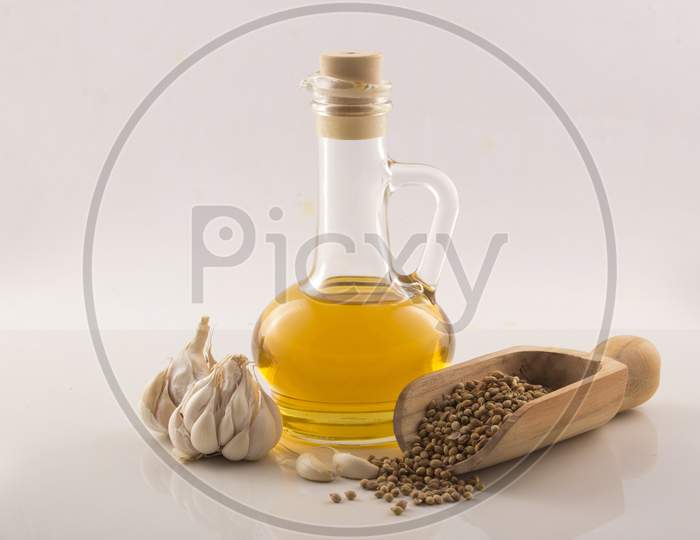 Garlic With Essential Oil In A Glass Jar With Wooden Spoon On White Background Stock Photo