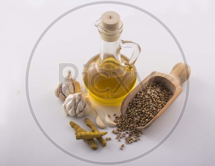 Garlic And Turmeric With Essential Oil In A Glass Jar Wooden Spoon On White Background Stock Photo