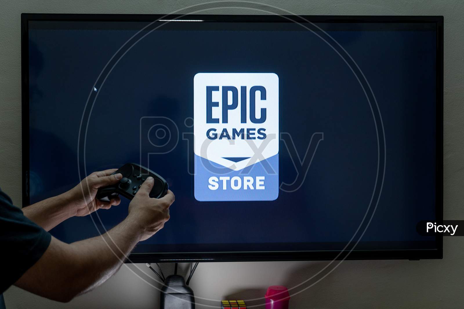 Man Holding Steam Controller Waiting For The Epic Game Store To Load An E-Store Of Reputed Games Used In E-Sports