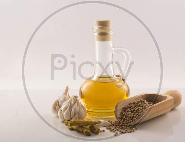 Garlic With Essential Oil In A Glass Jar Wooden Spoon On White Background Stock Photo