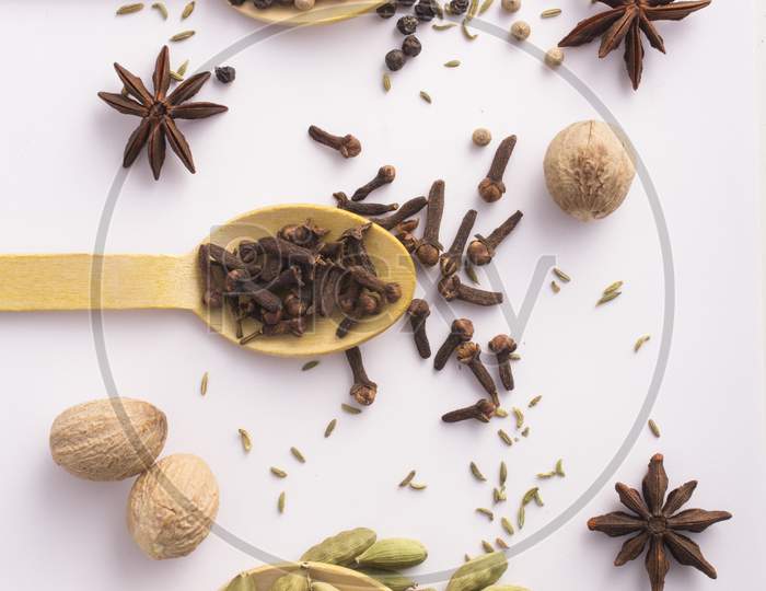 Wooden Spoons With Cloves, Cardamom  And Black Peppercorns Top View Stock Photo