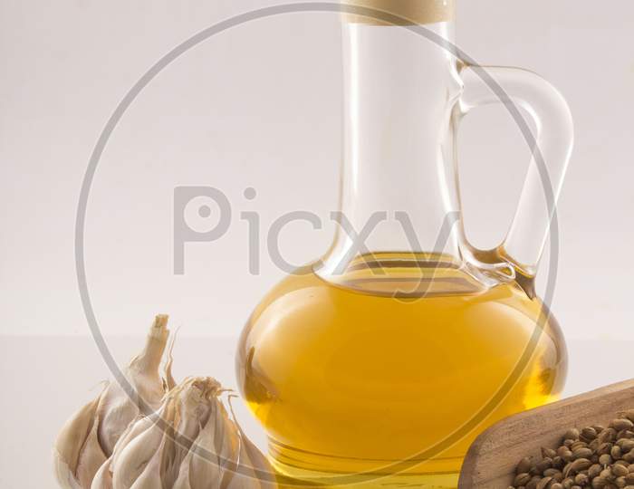 Garlic And Turmeric With Essential Oil In A Glass Jar Wooden Spoon On White Background Stock Photo
