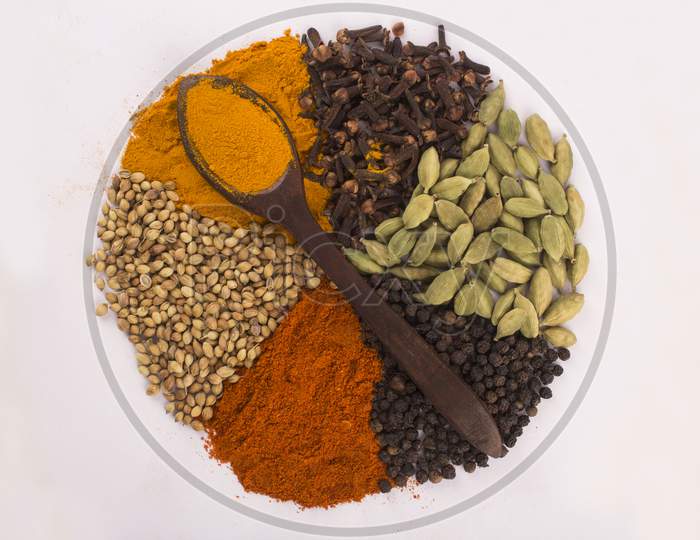 Spices: Turmeric, Chilly Powder, Black Pappercorns And Cloves On Ground With White Background Stock Photo