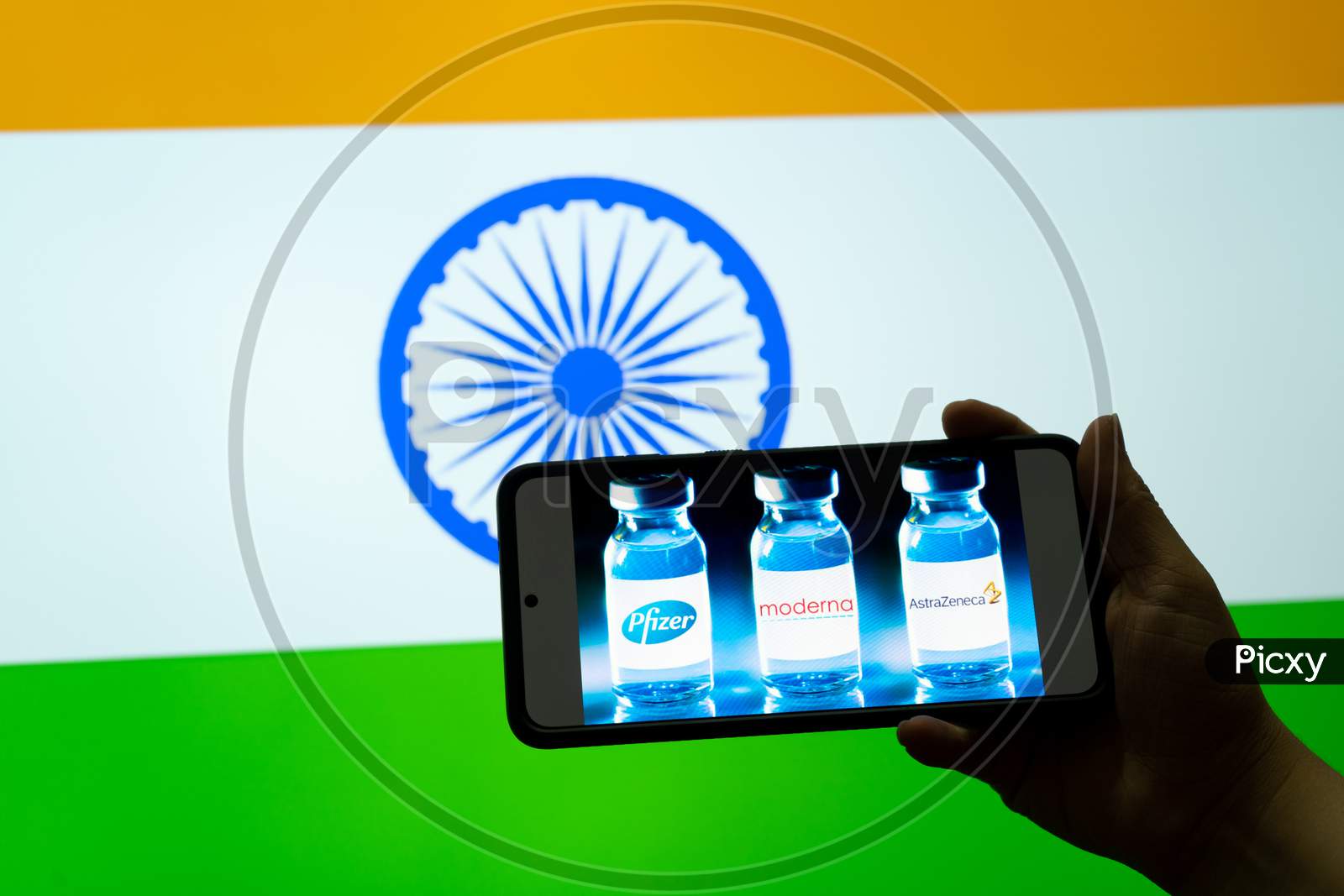 Man Holding Mobile Phone Showing Covid 19 Coronavirus Vaccine Choices Astrazeneca Moderna Pfizer In Front Of India Flag For Innoculation Against The Pandemic Epidemic
