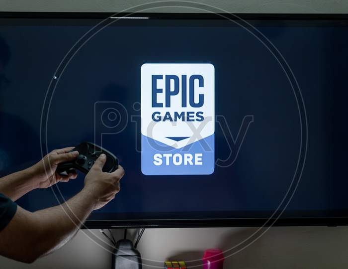 Man Holding Steam Controller Waiting For The Epic Game Store To Load An E-Store Of Reputed Games Used In E-Sports