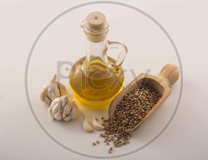 Garlic With Essential Oil In A Glass Jar With Wooden Spoon On White Background Stock Photo