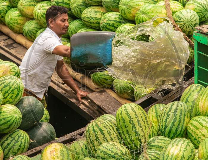 Man Cleaning Water From The Watermelon Boat