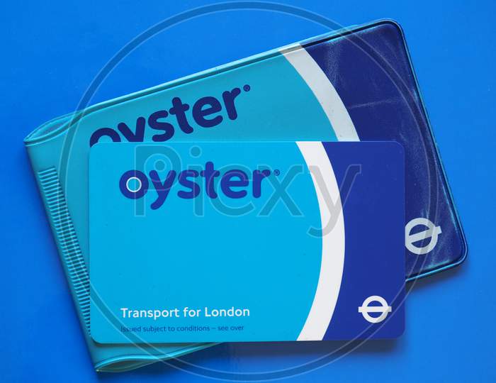 London, Uk - Circa December 2016: The Oyster Card Uses Near Field Communication Technology For Public Transport Ticketing In And Around London, Over Blue Background