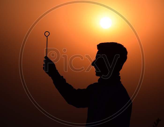 Stick On Boy Hand And Sunset Background