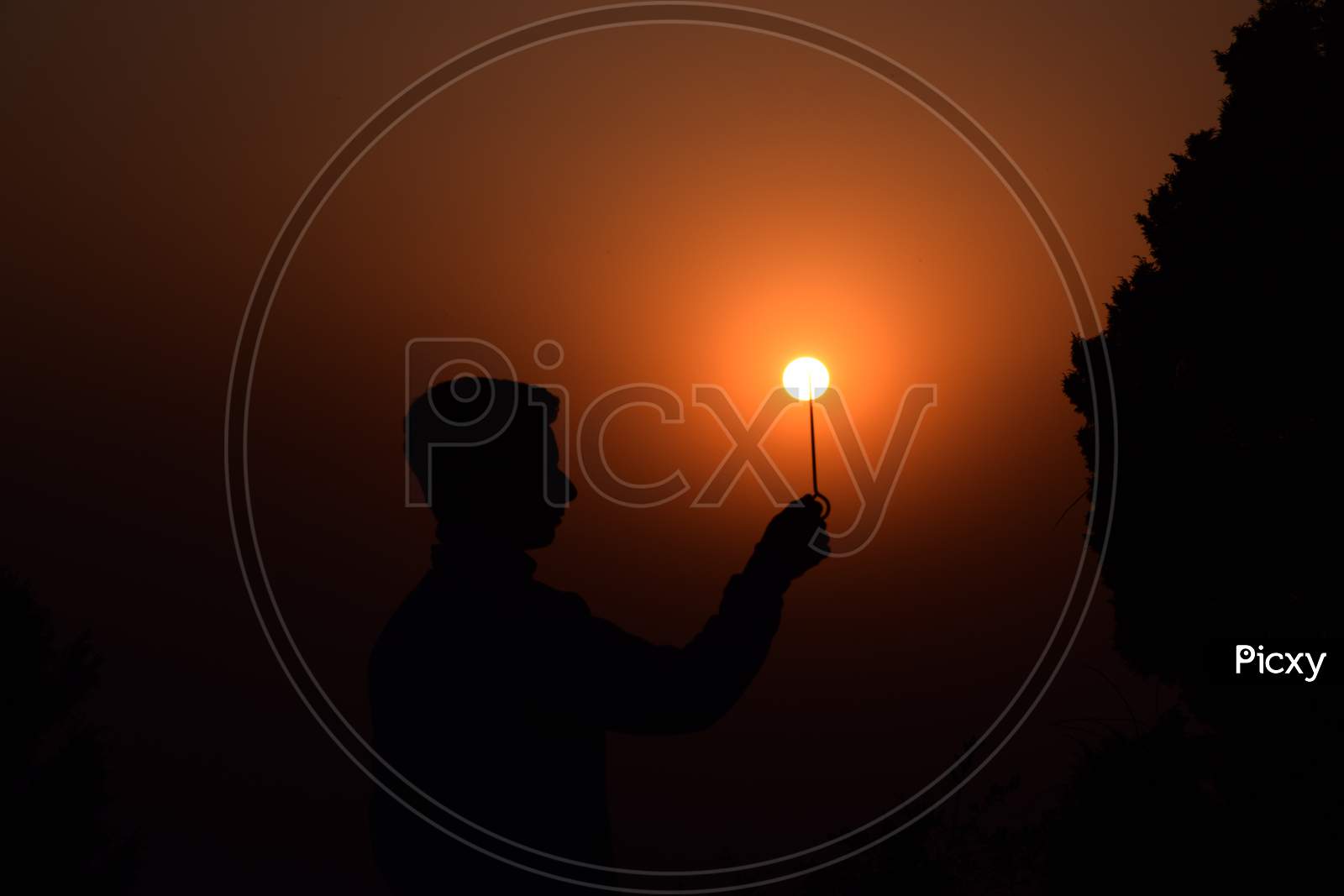 Boy Holds A Stick In His Hand. Beautiful Orange Sunset In Summer. Selective Focus, Selective Focus On Subject, Background Blur