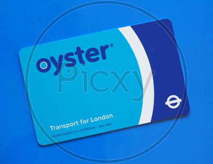 London, Uk - Circa December 2016: The Oyster Card Uses Near Field Communication Technology For Public Transport Ticketing In And Around London, Over Blue Background