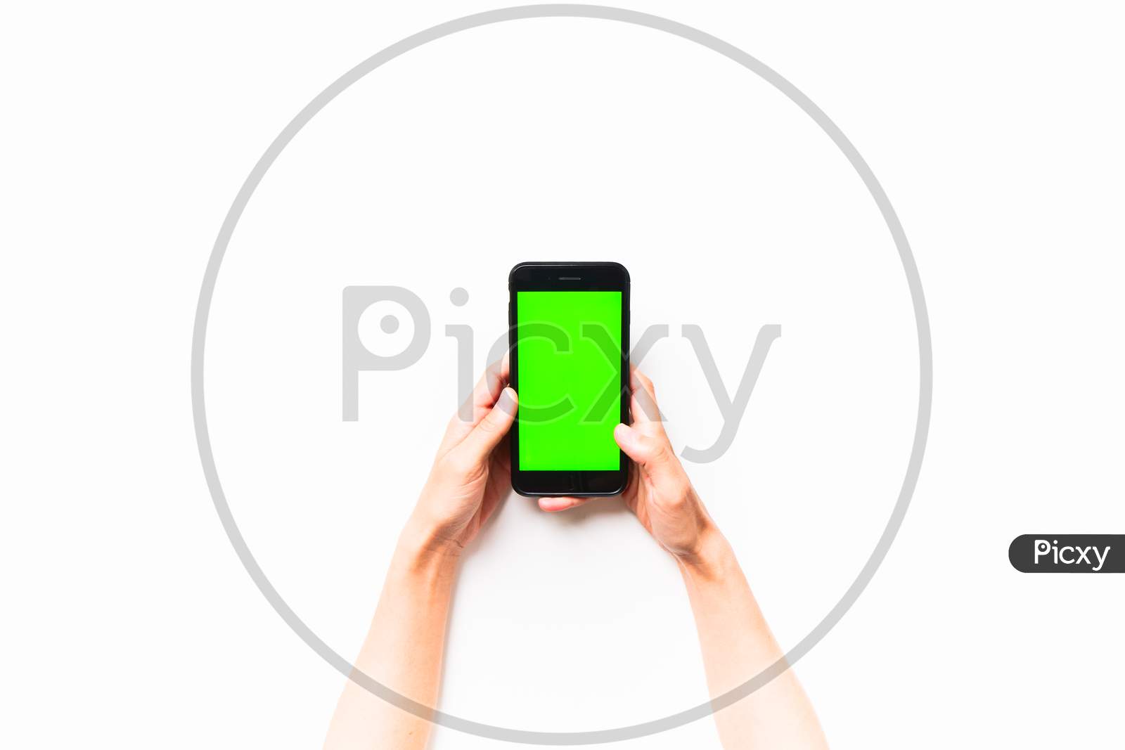 Woman Hand Holds Mobile Smartphone With Green Screen In Vertical Position Isolated On Green Background With Thumbs Up Finger. Mock Up Mobile Screen Blank Space