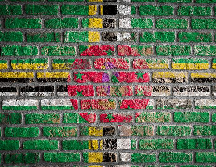 National Flag Of Dominica Depicting In Paint Colors On An Old Brick Wall. Flag  Banner On Brick Wall Background.