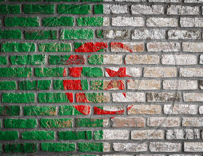 National Flag Of Algeria Depicting In Paint Colors On An Old Brick Wall. Flag  Banner On Brick Wall Background.