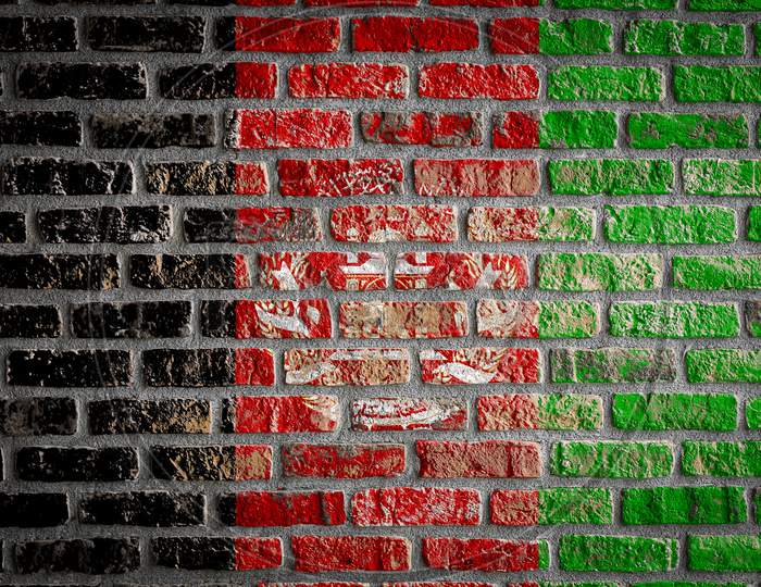 National Flag Of Afghanistan Depicting In Paint Colors On An Old Brick Wall. Flag  Banner On Brick Wall Background.
