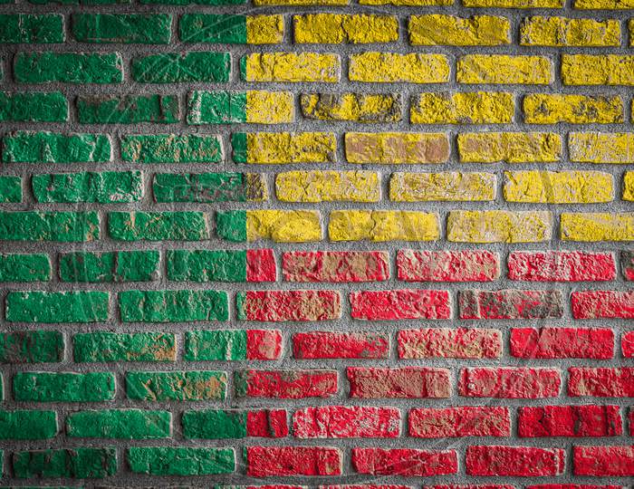 National Flag Of Benin Depicting In Paint Colors On An Old Brick Wall. Flag  Banner On Brick Wall Background.