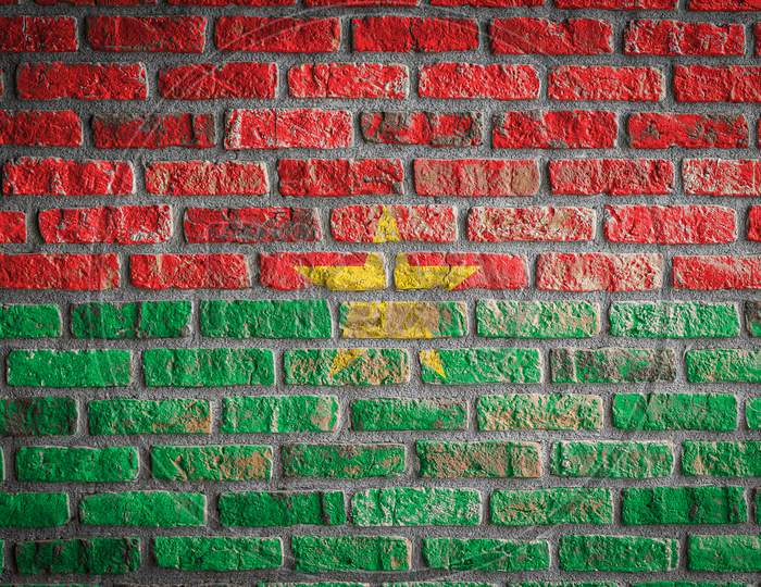 National Flag Of Burkino Faso
 Depicting In Paint Colors On An Old Brick Wall. Flag  Banner On Brick Wall Background.