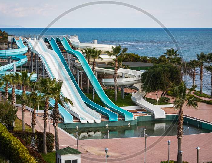 A Disabled  Aquapark  With High Slides By The Sea With A Large Untreated Pool Without People In A Hotel In A Tourist Town