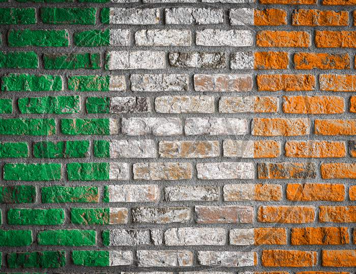 National Flag Of Ireland Depicting In Paint Colors On An Old Brick Wall. Flag  Banner On Brick Wall Background.