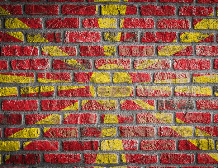 National Flag Of Macedonia Depicting In Paint Colors On An Old Brick Wall. Flag  Banner On Brick Wall Background.