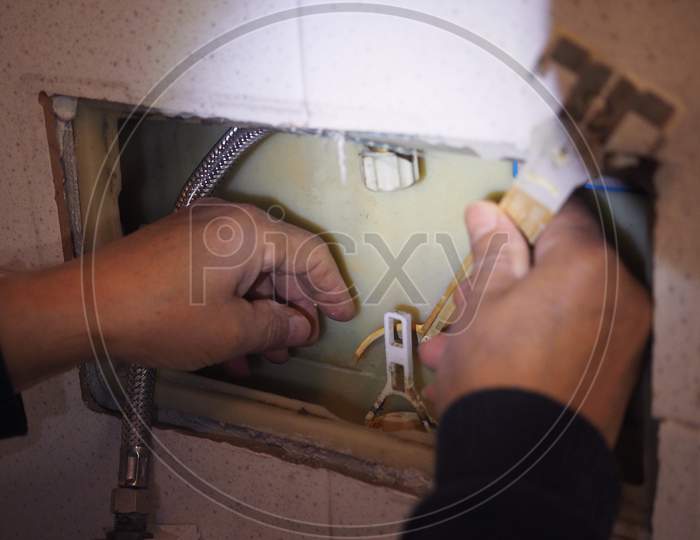 Plumber Repairing Toilet Tank