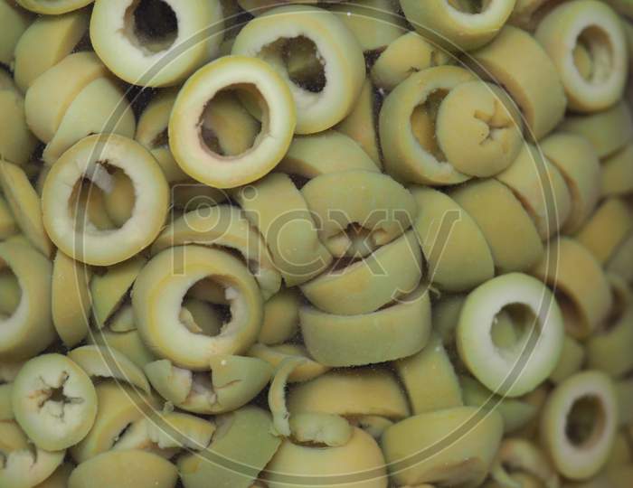 Sliced Green Olives In Brine Background