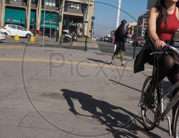Turin, Italy - Circa February 2019: Pedestrian And Woman On Bike In The City Centre