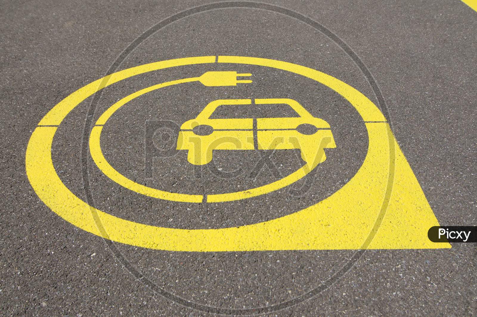 Yellow Electric Vehicle Charging Station Symbol On Asphalt