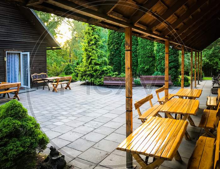 Holiday Villa House Yard With Wooden Tables And Greenery In Lithuania Countryside.