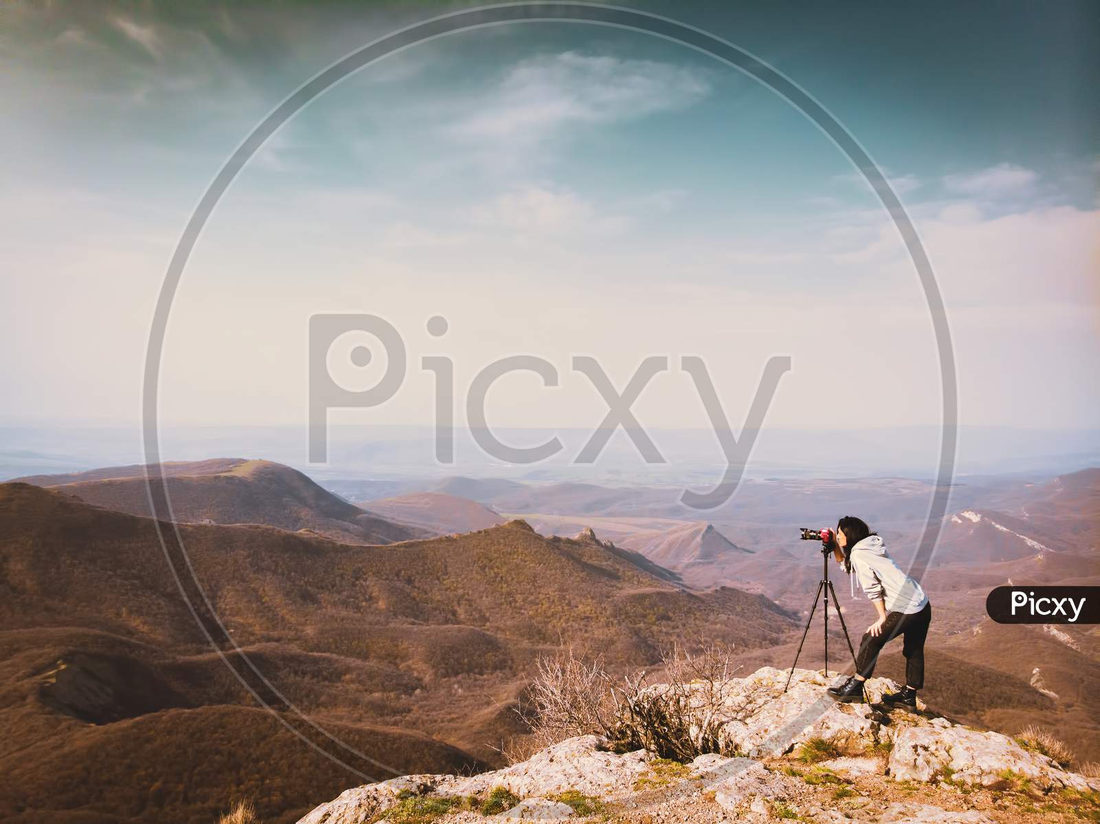 Side View Young Attractive Caucasian Hipster Woman Content Creator Photographing Mountains With Red Girly Dslr Camera On Tripod