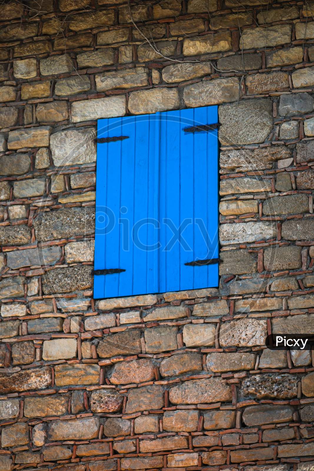 Close-Up Wall Of A Stone House With Wooden Window And Shutters. Old European Architecture
