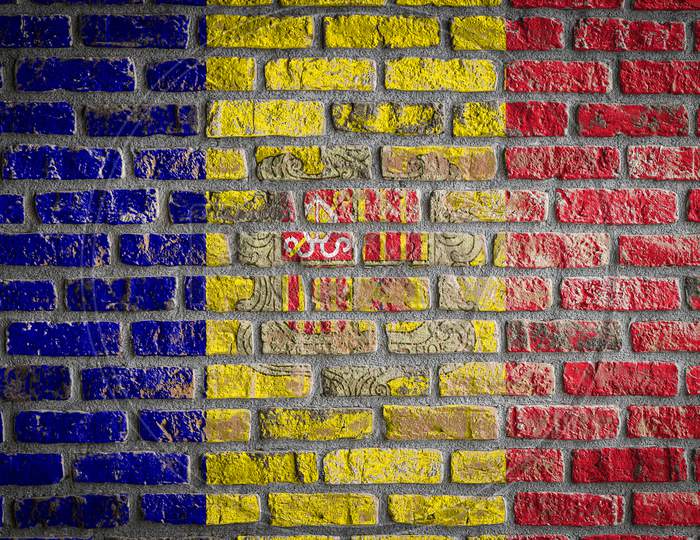 National Flag Of Andorra
 Depicting In Paint Colors On An Old Brick Wall. Flag  Banner On Brick Wall Background.