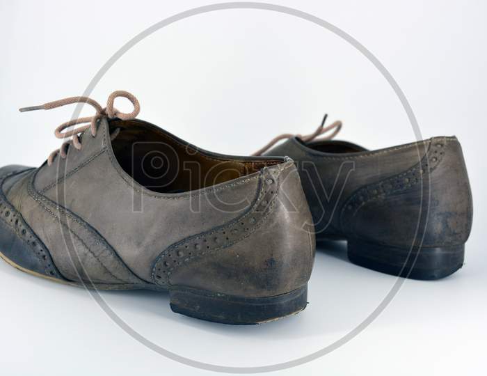 Female leather shoes located on a white background. Oxford shoes with gray shoelaces on a flat heel. Gray women's shoes in a fastening, unwitting.