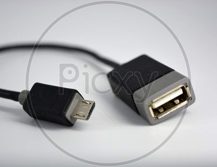 Adapter black wire for computer and phone is located on a white plastic background.