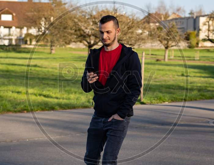 Young Man On Roller Blade Looking At His Phone. Technologie In Nature.